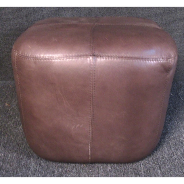 Plush vintage modern ottoman upholstered in a rich brown leather. Versatile size and shape allows it to be used...
