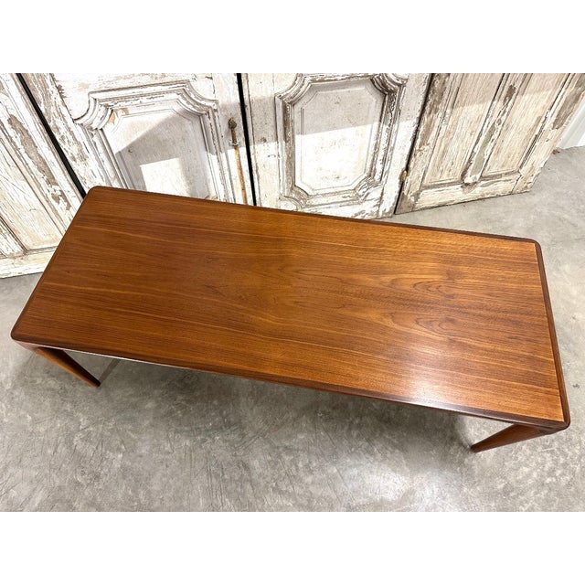 Teak coffee table from the 1960s. Features a small pull-out shelf on one side. Danish design attributed to johannes...