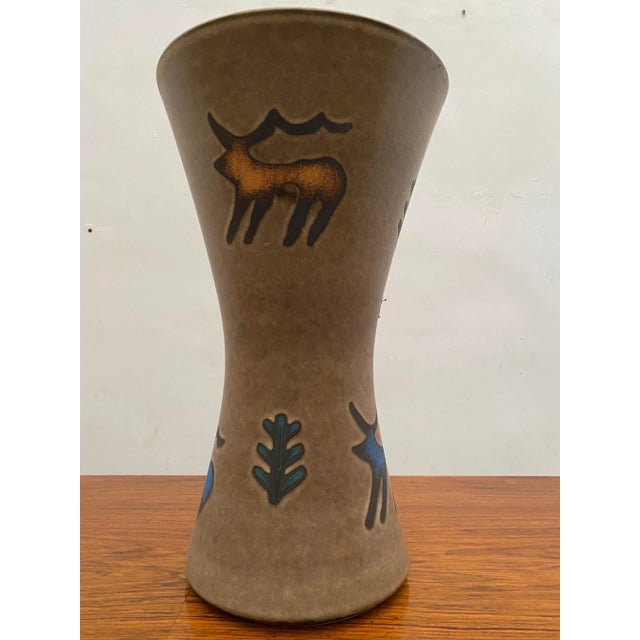 A Large ceramic vase designed with pre-historical animals in the colors blue and orange manufactured in Germany by Hohr in...