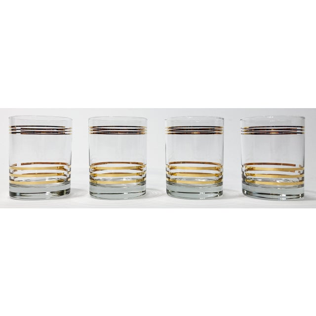 Rich looking set of four (4) vintage Mid Century Modern style lowball glasses. Small gold bands to top of glass with...