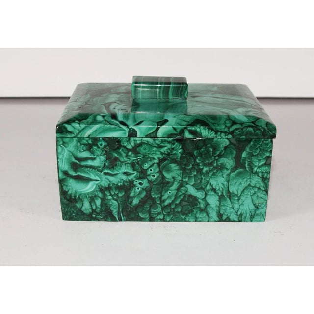 A Malachite stone rectangle stone box. Beautiful green veined. The box has a sperate top with stone handle. Measures 4 ¼”...