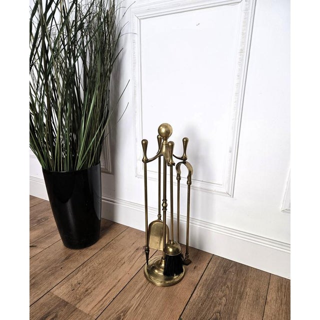 Italian brass four-piece fire tool set with stand. The set consists of a poker, a shovel, a brush and a pair of tongs,...