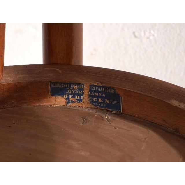 A set of two antique chairs in bentwood, with a curved crest rail over vertical splats and a moulded board seat....