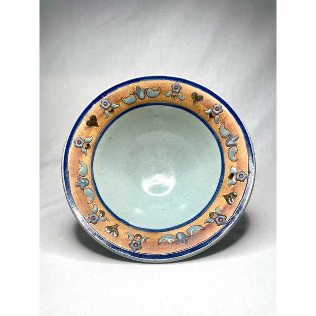 In folk art fashion this vintage decorative bowl is rimmed with symbols of hearts in a gold finish, flowers with red-...