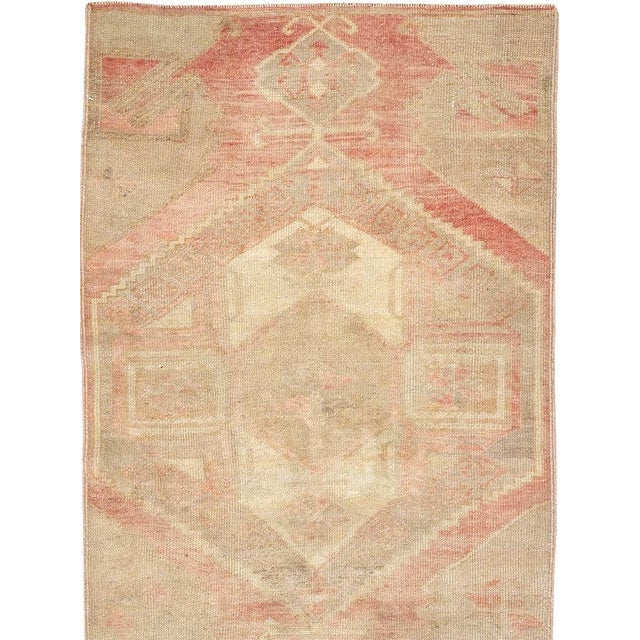 This mid-20th-century Turkish Anatolian runner presents a softly layered composition in muted tones of sand, blush, pale...