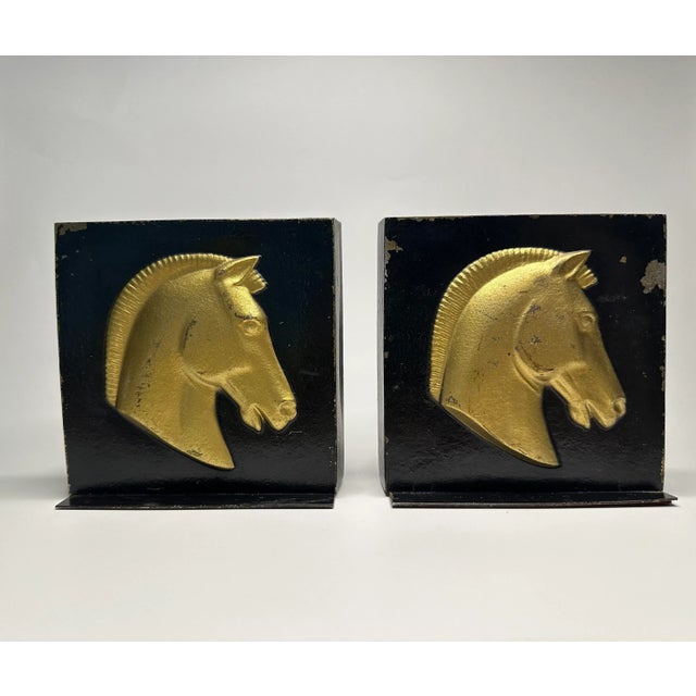 The classic colors of black and gold paint adorn this pair of vintage bookends. Each piece displays a detailed embossing...