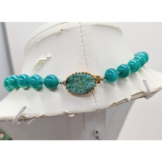 1960s goldtone single strand faux-jade spherical beads hand knoted with carved oval faux-jade box clasp. Marked "JOSEPH...