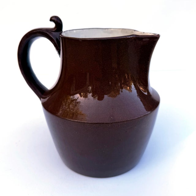 Lovely antique Sarreguemines one-handled pitcher with a warm brown glaze and clean white interior. Marked “Sarreguemines”...