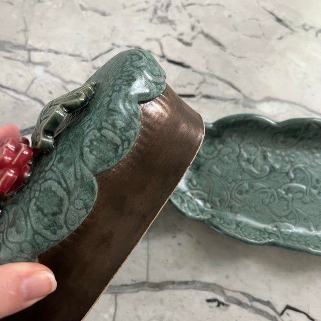 Beautiful handmade butter dish and lid. Colors are turquoise and bronze with a pink flower on top. Has a pattern etched...