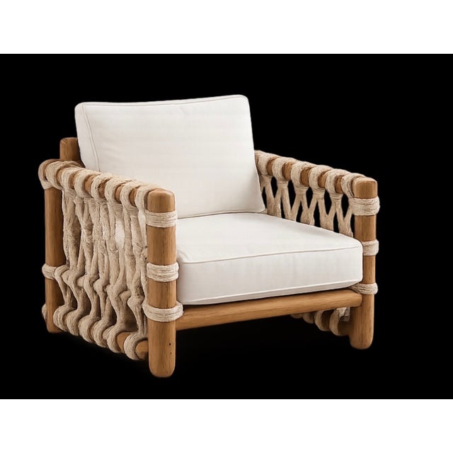 A striking organic modern lounge chair crafted from solid teak with handwoven natural rope detailing along the arms and...