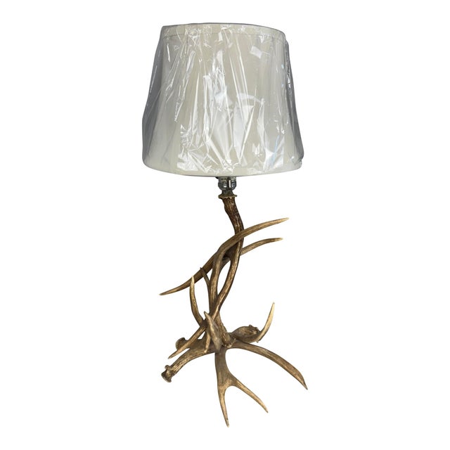 This distinctive table lamp features an authentic antler base with natural branching tines that create an organic,...