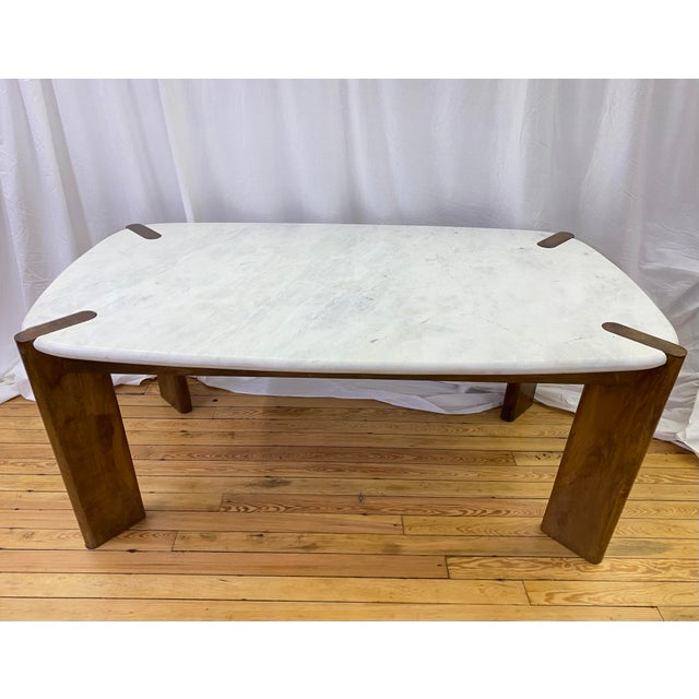 Harp & Finial Noland dining table featuring a rectangular white marble top paired with a mango wood base in a walnut...