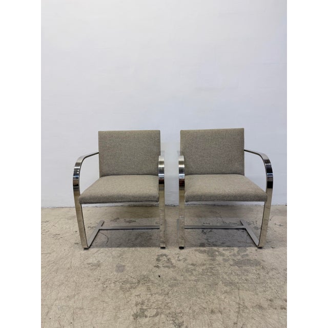 Pair of original Brno flat bar stainless steel and fabric arm chairs designed by Mies Van Der Rohe and manufactured by...