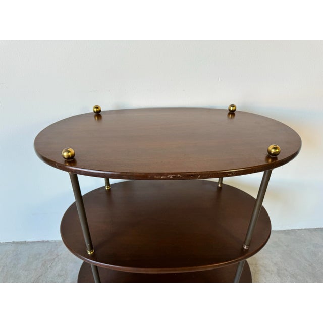 A stylish Vintage Baker Campaign - style solid mahogany oval three - tier side table. Featuring three - tiered solid...