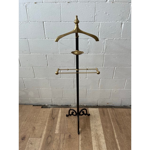 Beautiful brass and iron gentleman's valet. Solid brass elements to include coat hanger topped with finial, shell form...