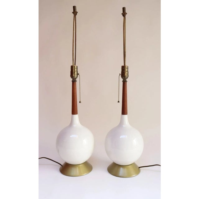 Pair of Mid-Century Modern table lamps, ca. 1960s, Denmark. Composed of a white ceramic vasiform orb supported by a...
