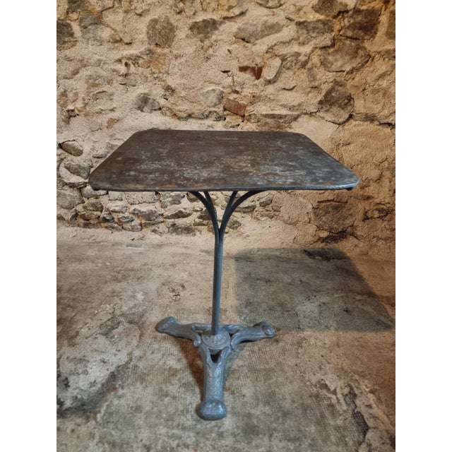 This antique French bistro table dates back to the 1920s and features a grey cast iron base with a beautifully aged patina...