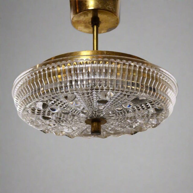Single stem pendant light of cast glass with brass fittings attributed to Carl Fagerlund for Orrefors. The glass is...