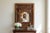 A beautifully detailed vintage Indian carved wood architectural mirror featuring a pair of functional hinged shutters that...
