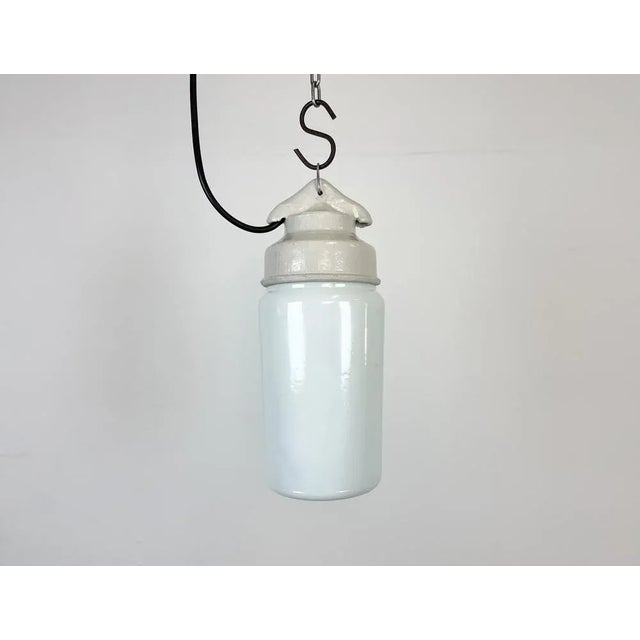 Vintage industrial light made in former Soviet Union during the 1970s.It features a white porcelain top and a milk glass...