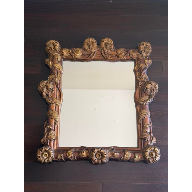 An exceptionally sculptural carved wall mirror featuring deep relief ornament, layered foliate carving, floral rosettes,...