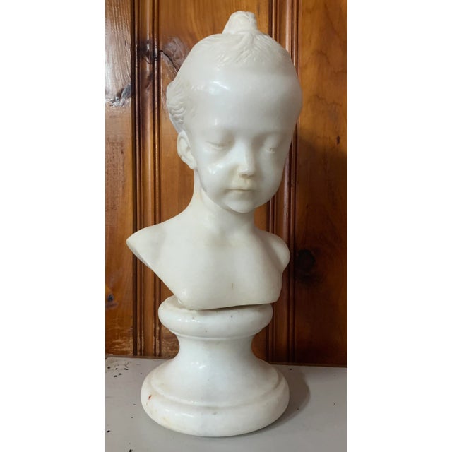 Antique carved marble bust of a serene young girl mounted on a marble base. Great quality and condition, realistic with...
