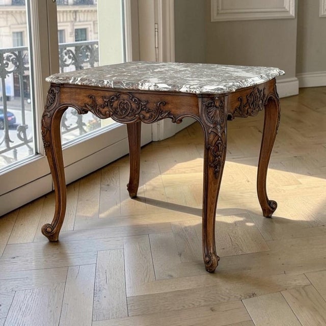 French Régence style carved oak end table crowned with a finely figured Sainte Anne marble top. The shaped apron is richly...