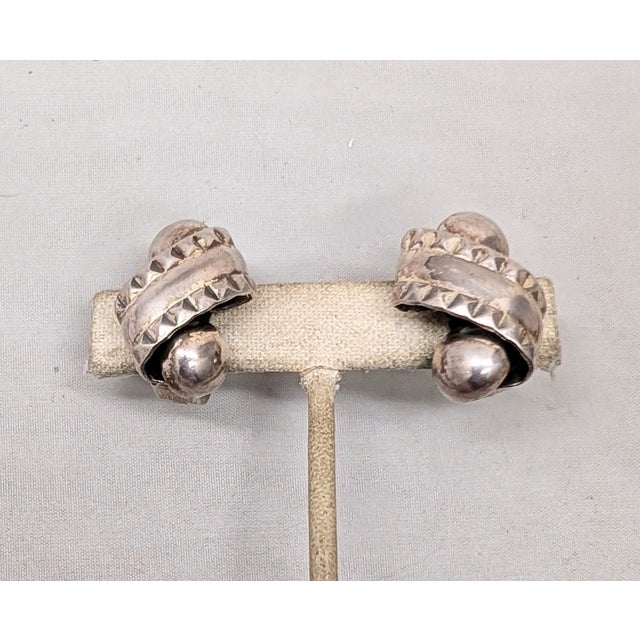 1950s silvertone scroll with studded design along the edges with a ball at the top and bottom clip earrings. Marked...