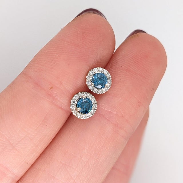 Make a statement with these icy blue Blue Diamond stud earrings, set in solid 14K White Gold. Each earring centers a hand-...