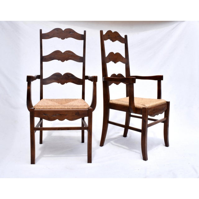 A pair of scalloped, high ladder-back chairs with contoured armrests, carved apron detailing, H stretchers & classic hand...
