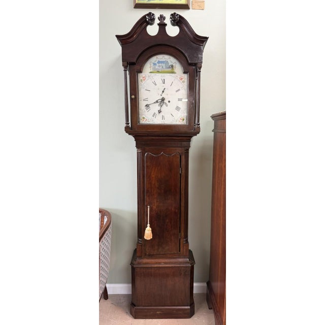 This Early American grandfather clock, attributed to James Wilson, features a stately dark wood case with a broken-arch...