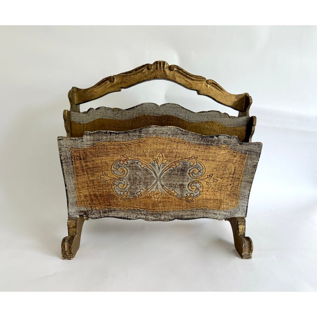 This Hollywood Regency style giltwood Florentine magazine stand has an uncommon gold and gray/silver color way. The...
