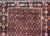 A beautiful early 20th century Persian Baluch rug with an all-over stylized flower pattern woven in red, orange, and black...