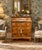 Elegant Biedermeier-style tall chest of drawers featuring dramatic book-matched crotch mahogany veneer, a concealed...