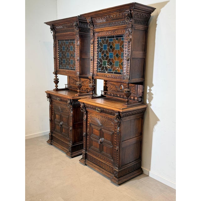 Beautiful and highly decorative pair of antique solid oak display cabinets, crafted in a rich Neo-Renaissance style. These...