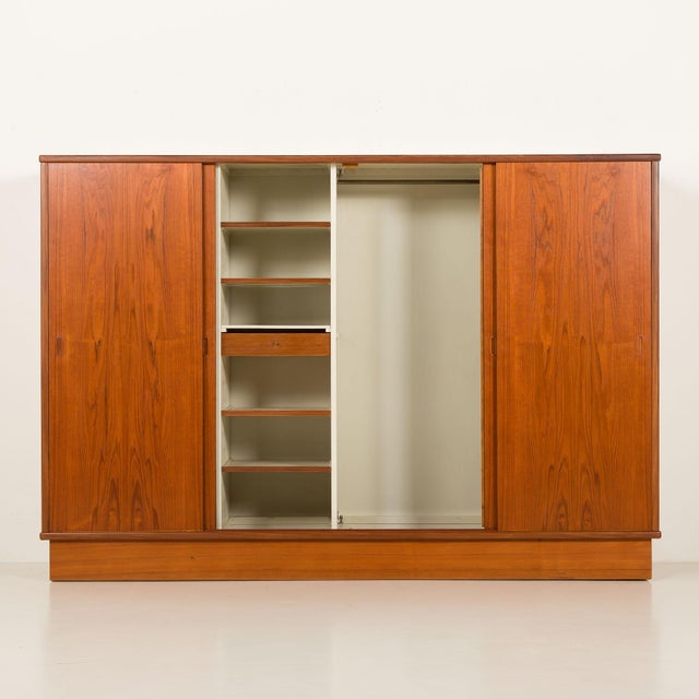This large mid-century teak wardrobe was made in Denmark in the the 1960s. The overall size is H: 174 / W: 253 / D: 65 cm....