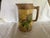 This is a classic majolica cream or milk pitcher. pitcher, . It has a simulated banded wood background on which a daisy...