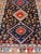 This vintage Persian Shiraz features a rich navy blue background under the centered red medallions, edged with green,...