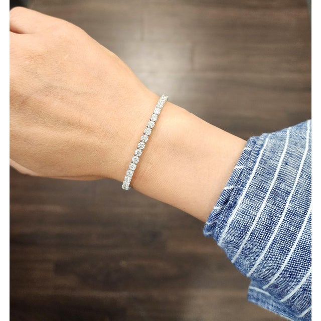 A modern tennis bracelet crafted in 14k white gold, featuring 7.42 carats of natural 50 round white diamonds, graded G/H...