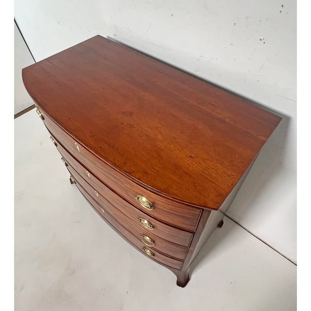 Federal Period bow front chest of drawers in mahogany, ca. 1820. It features beaded drawer fronts, oval brasses, whalebone...
