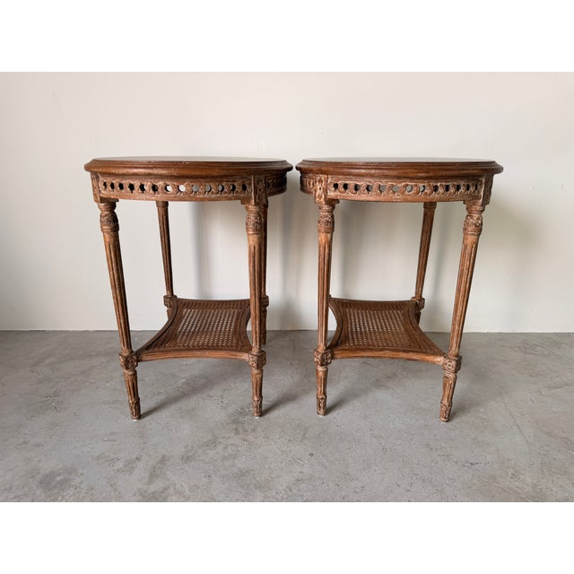 Elegant Louis XVI style side tables featuring oval tops. Their refined neoclassical details paired with a warm distressed...