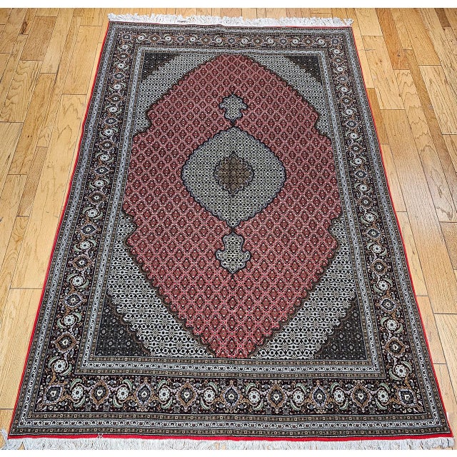 This vintage Persian Tabriz Mahi rug, crafted in the third quarter of the 1900s, beautifully showcases the timeless...
