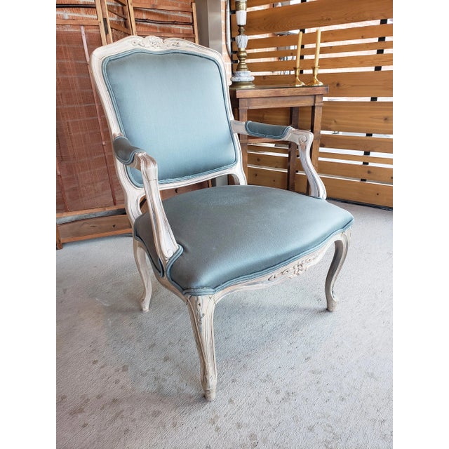 Handsome Louis XV style armchair with a distressed painted wooden frame. The original cotton fabric is an interesting blue...