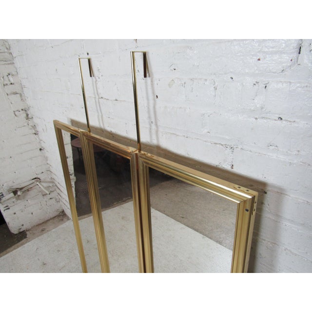 Brass frame door hanging mirror with three panels. Can open to three mirrors, or close to a single mirror.