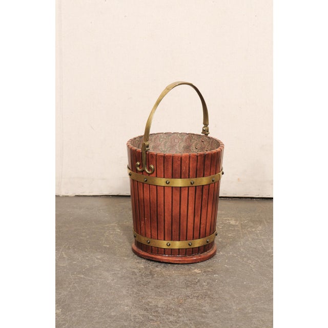 An English wood and brass decorative bucket with a handle from the 19th century. This antique bucket from England is round...