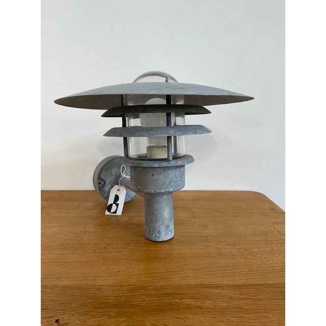 Upgrade your home’s curb appeal with the sleek, industrial aesthetic of the Nordlux 'Pheonix' outdoor sconce. Designed in...