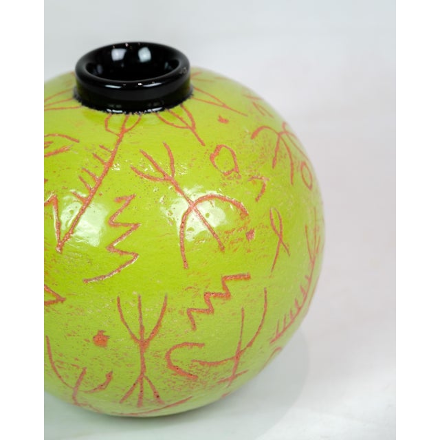 Lene Regius' round vase with black top, green glaze and orange patterned engravings from around the 1990s represents a...