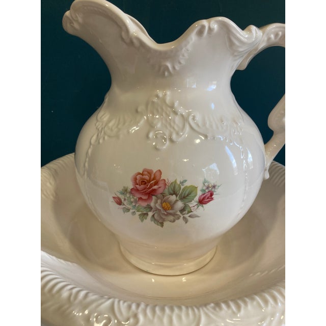 This vintage Arnels ceramic wash basin and pitcher set features an elegant ivory glaze, embossed detailing, and a colorful...