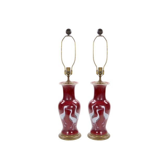 Striking pair of decorative table lamps featuring sculptural deep burgundy-red porcelain bodies in elegant baluster forms....