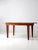 An antique primitive dining table featuring a wide plank top and simply tapered legs. The rustic wooden construction and...